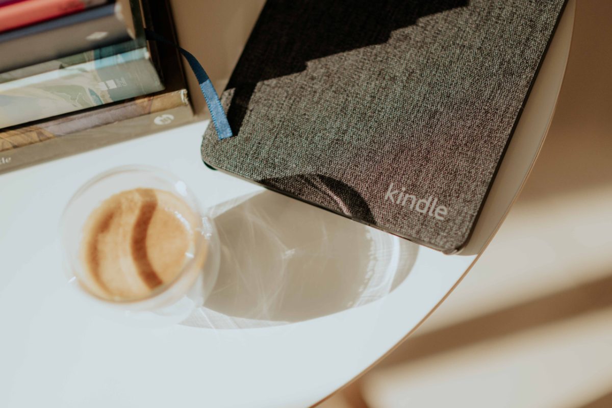 Livro aberto ao lado de uma xícara de café