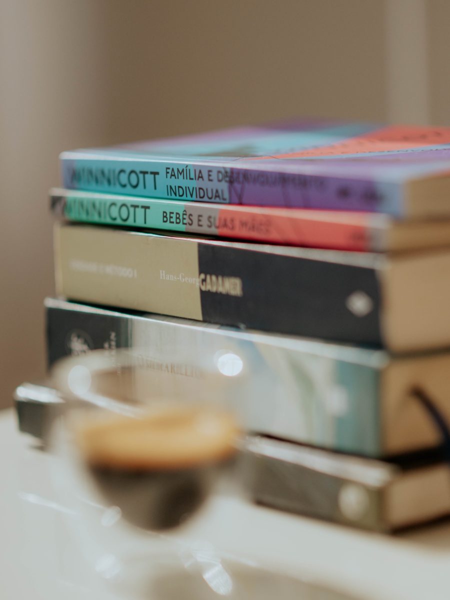 Livros de psicanálise empilhados sobre a mesa de trabalho